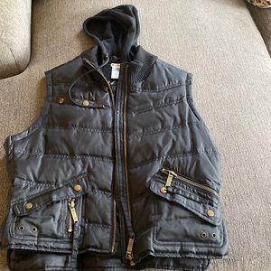 Puffer vest with hoodie has pockets with zippers on front zipper closure